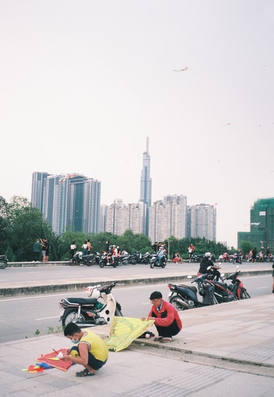 人们白天在城市建筑物附近的道路上骑摩托车